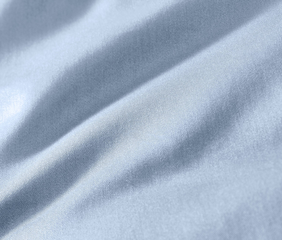 Nahaufnahme von hellblauer Baumwollsatin-Bettwäsche in Übergröße.