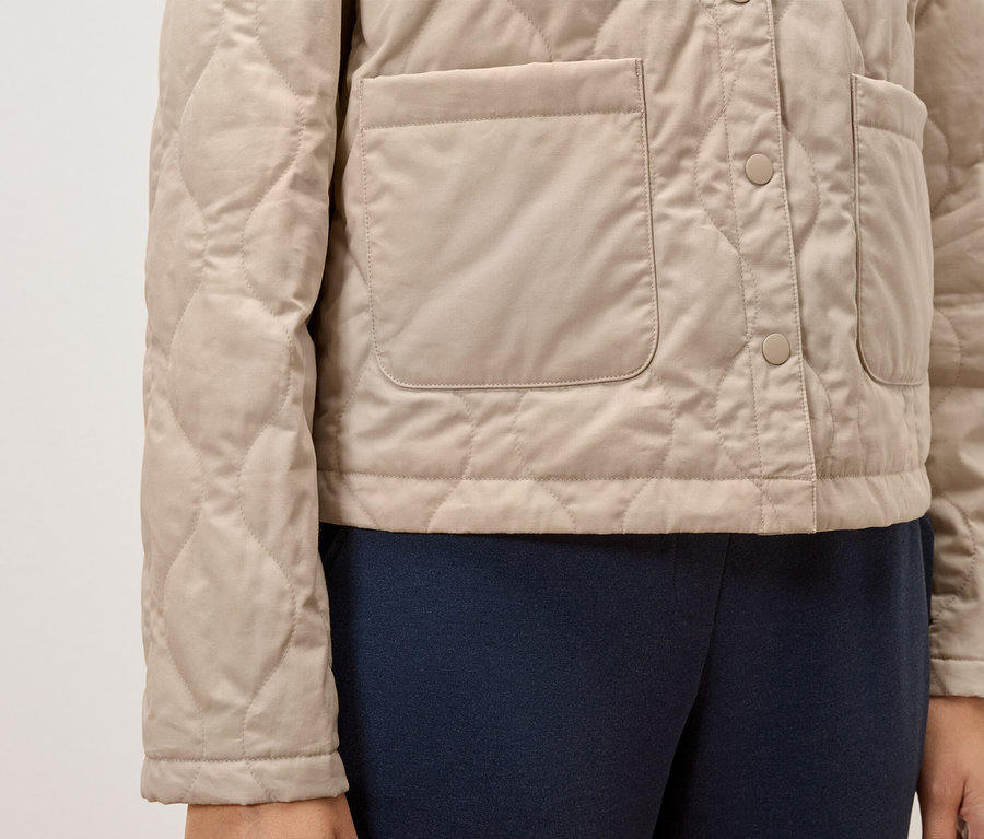 Beige gesteppte Jacke mit Knöpfen und Taschen.
