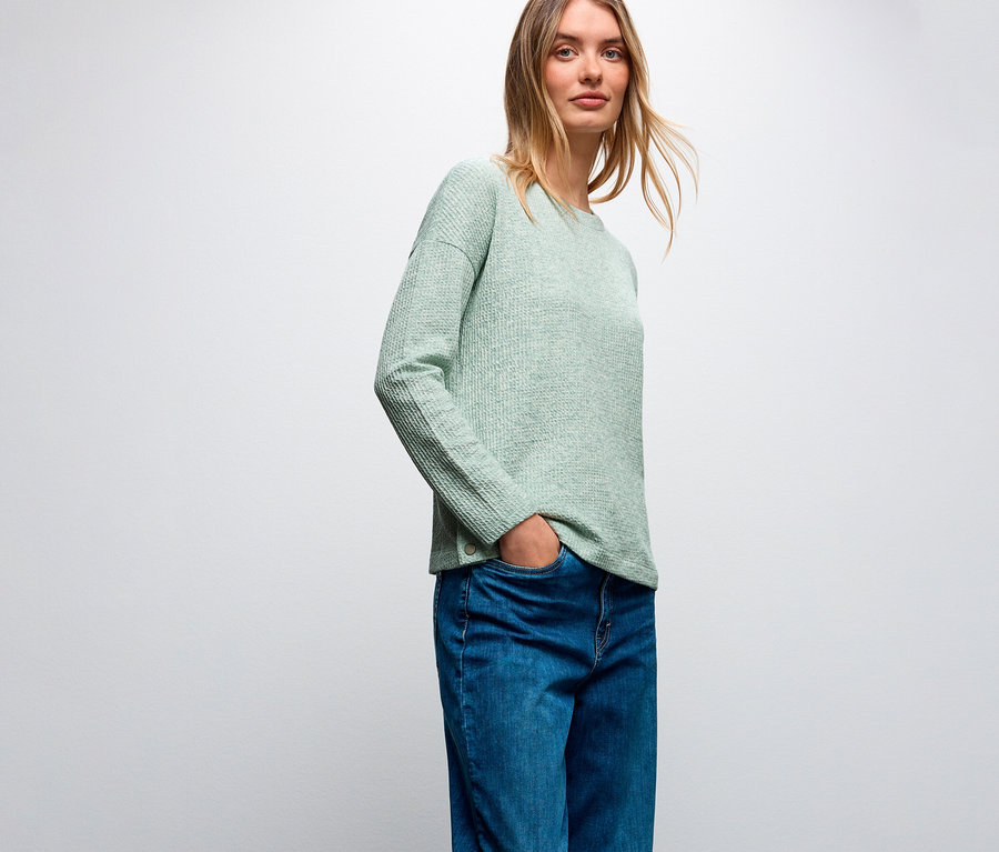 Frau mit einem hellgrünen Street One Shirt mit Struktur und Bluejeans.