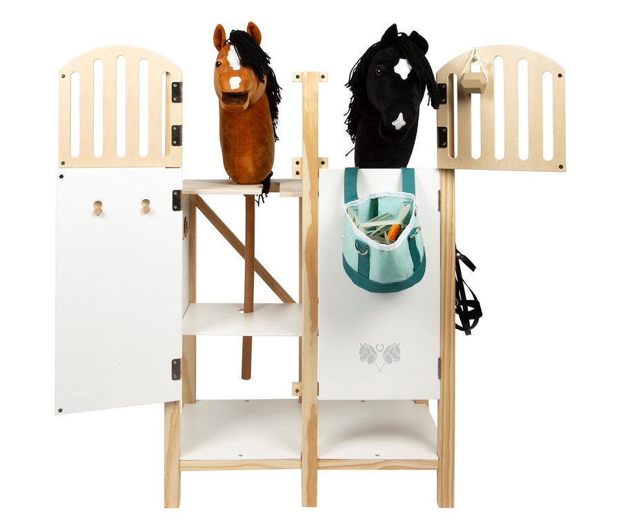 Der small foot Hobby-Horse-Pferdestall mit zwei Steckenpferden, einem blauen Sack mit Karotten und einer offenen Tür.
