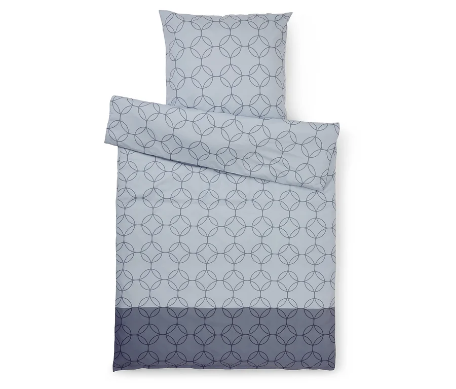 Draufsicht auf ein hellblaues Bettwäsche-Set mit Kreismuster und dunkelblauem Rand.