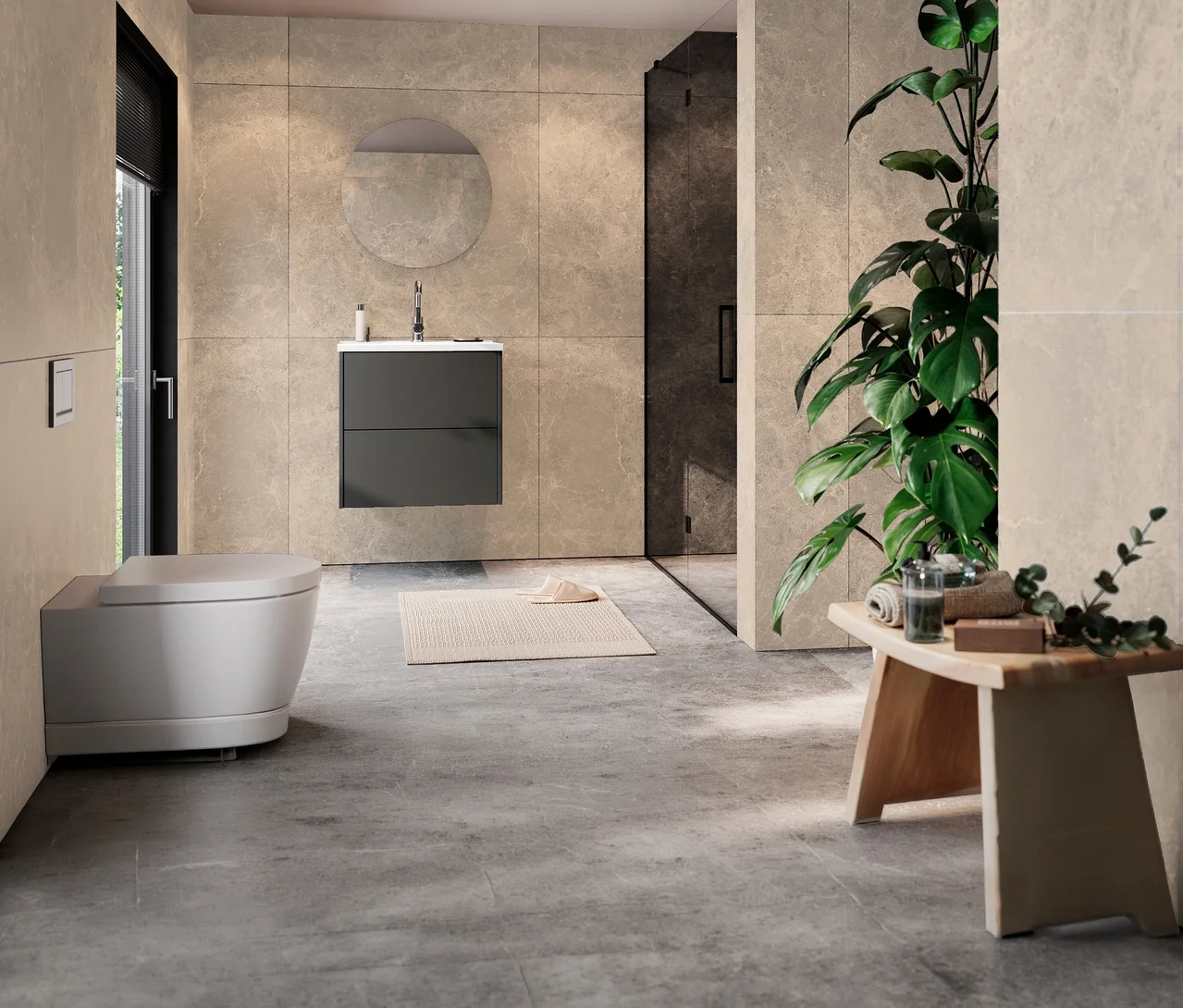 Modernes Badezimmer mit weißem Hänge-WC, graphitfarbenem Waschtisch Bodera mit Becken unter rundem Spiegel. Rechts begehbare Dusche, große Pflanze und Holzhocker mit Handtüchern.