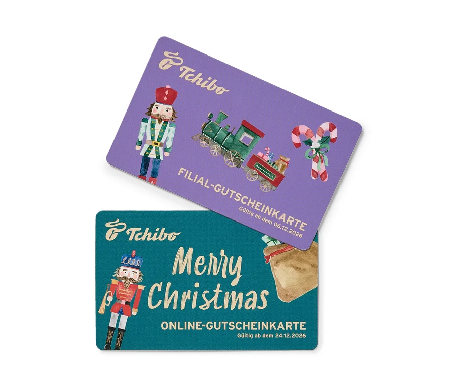 Zwei weihnachtliche Tchibo Gutscheinkarten. Die obere violette Karte zeigt einen Nussknacker, einen Spielzeugzug mit Geschenken und Zuckerstangen, beschriftet mit "FILIAL-GUTSCHEINKARTE". Die untere türkise Karte zeigt einen Nussknacker und einen Geschenkesack mit dem Text "Merry Christmas ONLINE-GUTSCHEINKARTE".