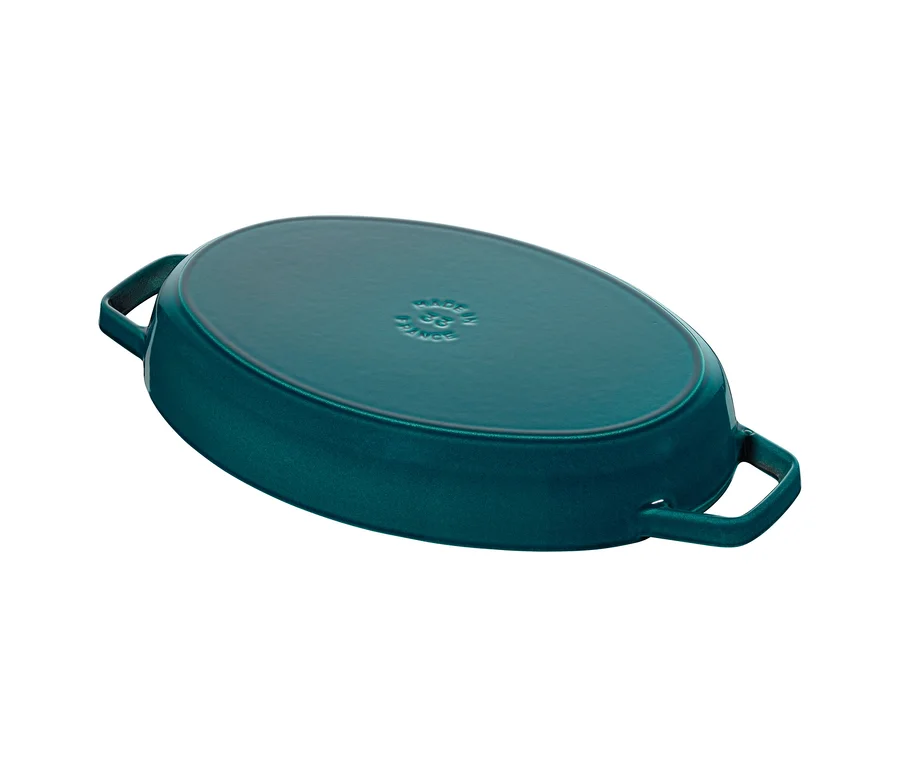 Ovale, dunkelgrün-blaue Auflaufform-Deckelunterseite mit Griffen, auf der "MADE IN FRANCE" und "33" eingeprägt ist.