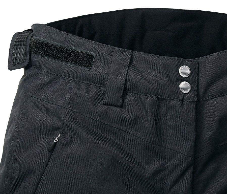 Detail einer schwarzen Skihose mit Knopfverschluss, Gürtelschlaufe und Reißverschlusstasche.