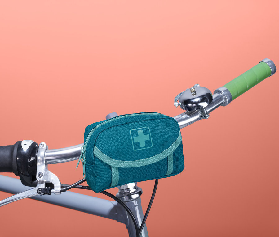 Eine blaugrüne Erste-Hilfe-Tasche ist an einem Fahrradlenker befestigt.
