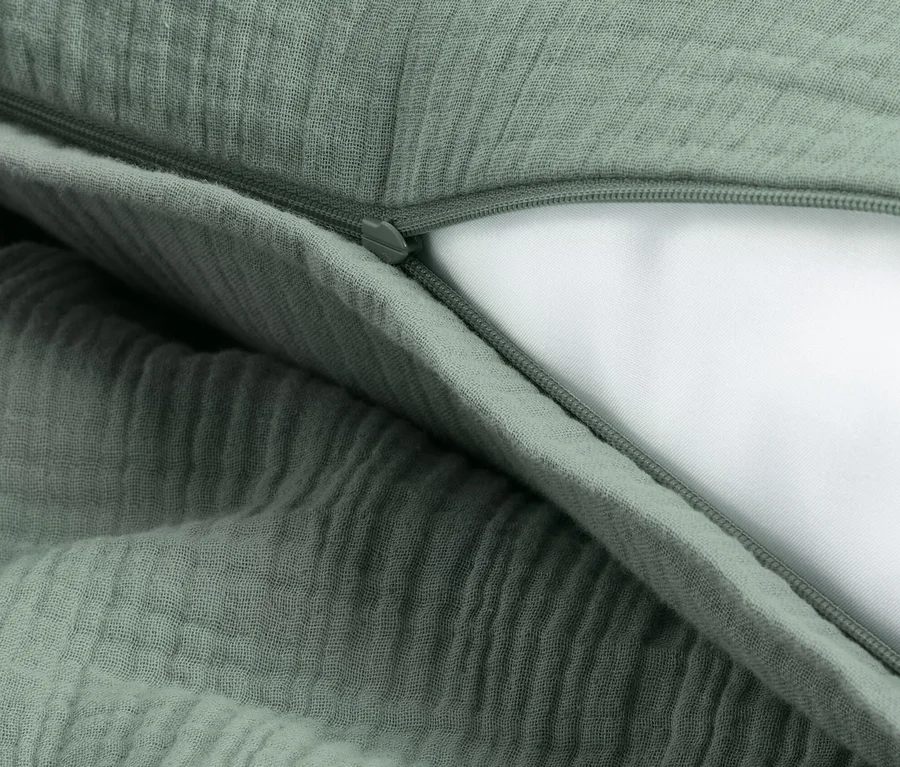 Detailaufnahme von grüner Musselin-Bettwäsche in Normalgröße mit Reißverschluss.