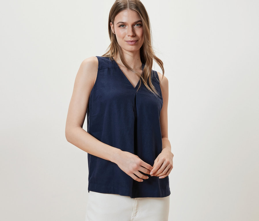 Frau posiert in ärmelloser Leinenbluse, navy.