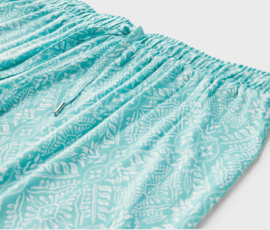 Detailaufnahme einer hellblauen Relaxhose mit weißem Muster.