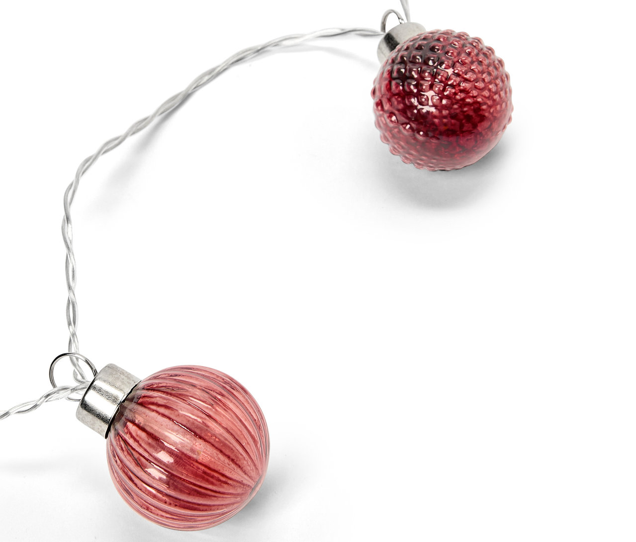 Zwei rote dekorative Kugeln an einem silbernen Draht auf weißem Hintergrund.