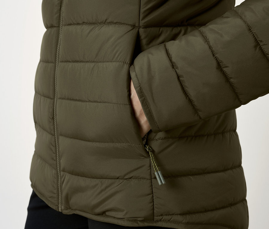 Detailaufnahme einer olivgrünen Steppjacke mit Hand in der Tasche.