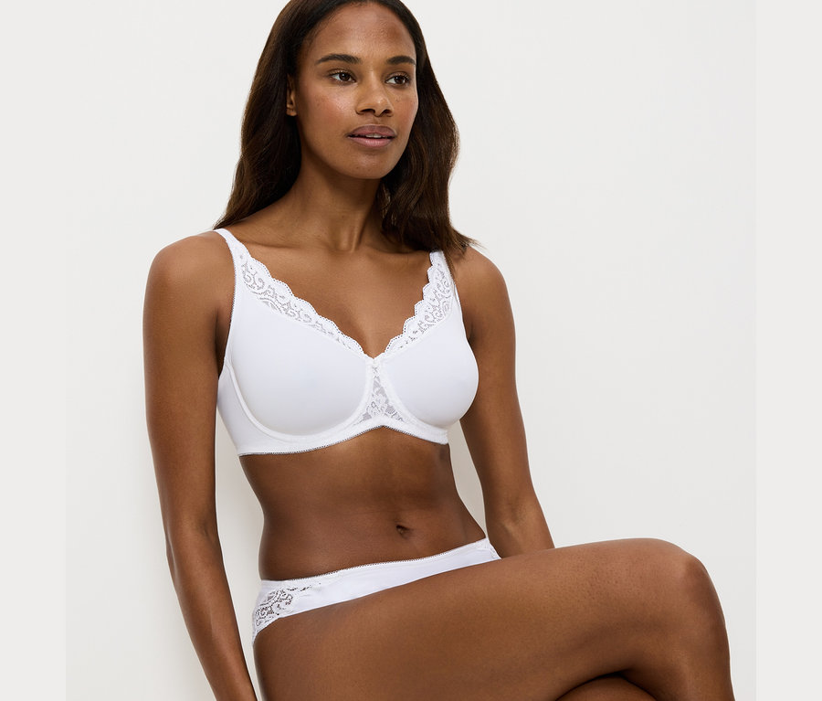 Frau trägt weißen Triumph Amourette Minimizer-BH und Höschen.