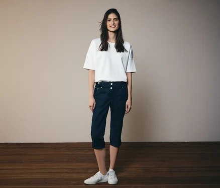 Frau in weißem T-Shirt und Cecil 3/4-Hose »New York« in Navy, dazu weiße Sneaker.