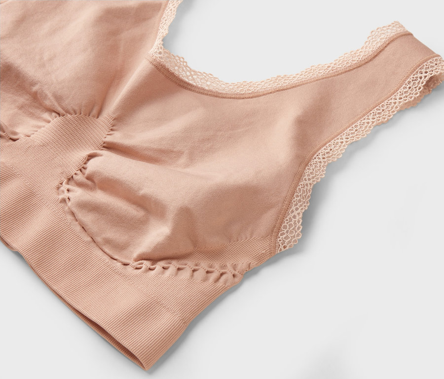 Nahaufnahme eines hautfarbenen BHs mit Spitze am Ausschnitt.
