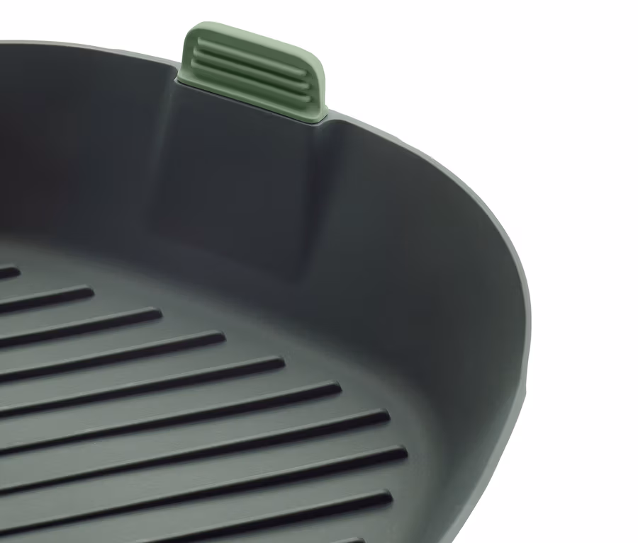 Nahaufnahme einer quadratischen, grauen Grillpfanne mit einem grünen Griff.