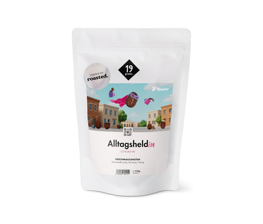Weiße Tüte „19grams x roasted. - Alltagsheldin Co-Roast #3 Omni-Roast - 250 g Ganze Bohne“ mit Stadt- und Superheld-Kaffeebohnen-Illustrationen.