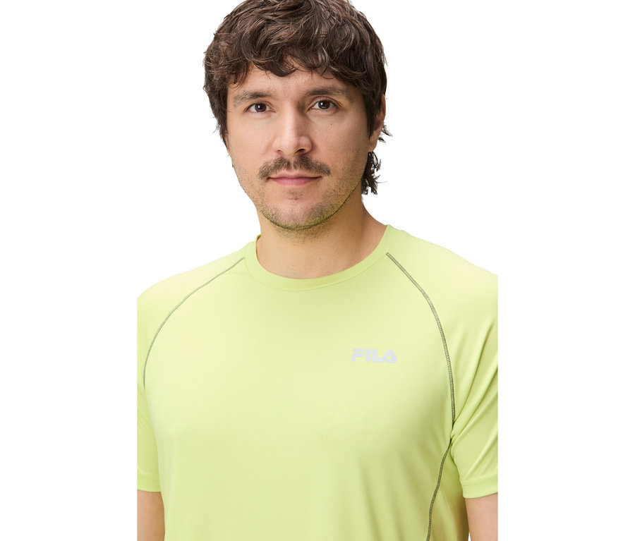 Mann trägt ein limegrünes FILA Herren-Funktionsshirt mit dunklen Nähten und FILA-Logo auf der Brust.