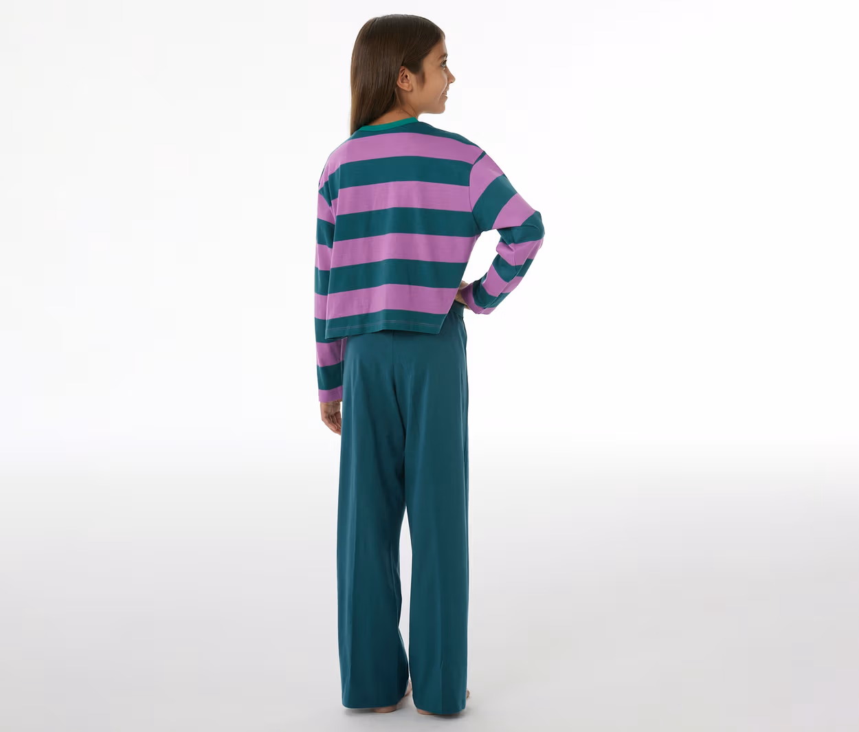 Kind von hinten, das einen SCHIESSER Kinder-Pyjama trägt, bestehend aus einem lila-grün gestreiften Langarmshirt und einer grünen Hose mit weitem Bein.