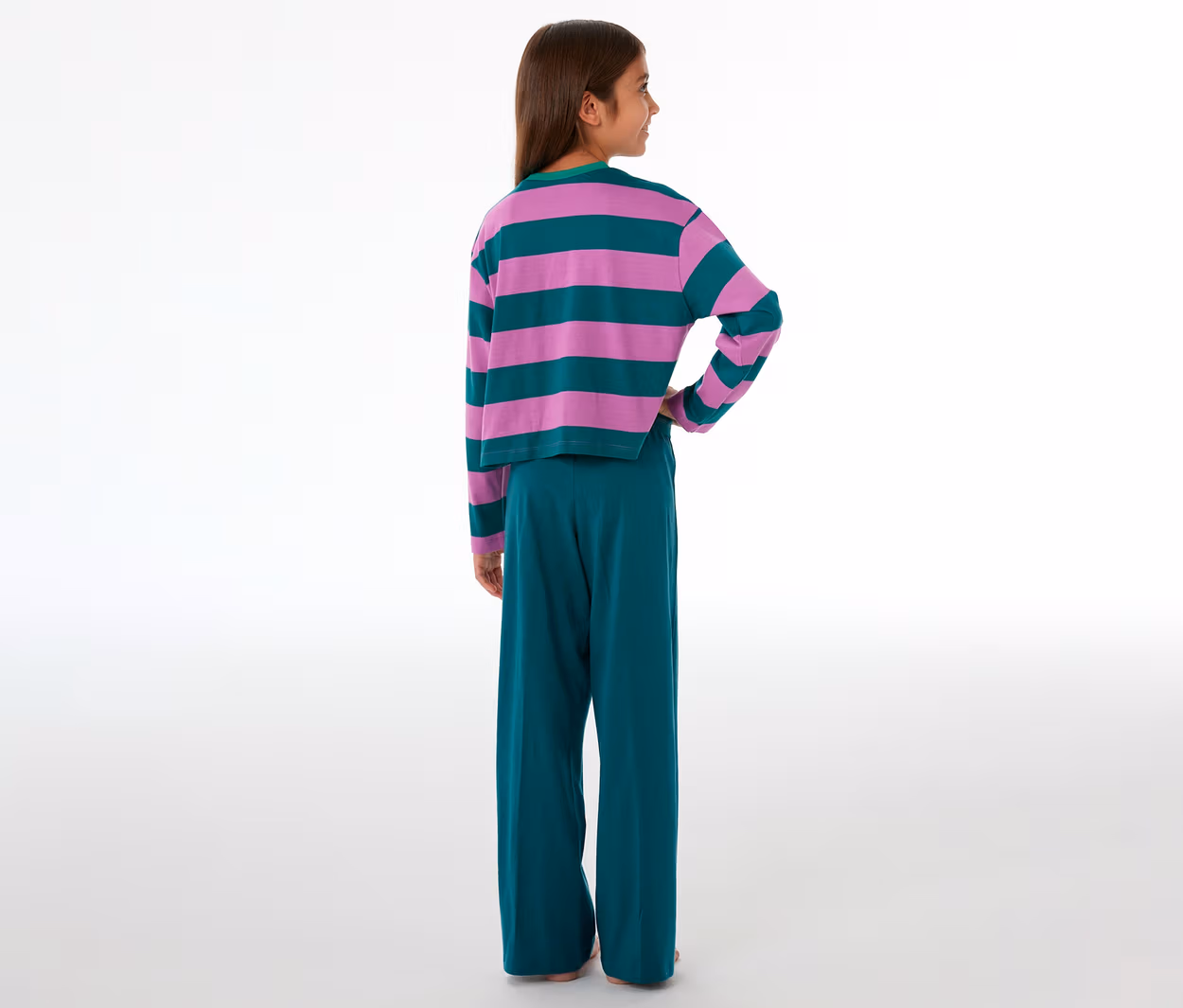 Mädchen von hinten in einem SCHIESSER Kinder-Pyjama mit pink-grün gestreiftem Oberteil und grüner Hose.