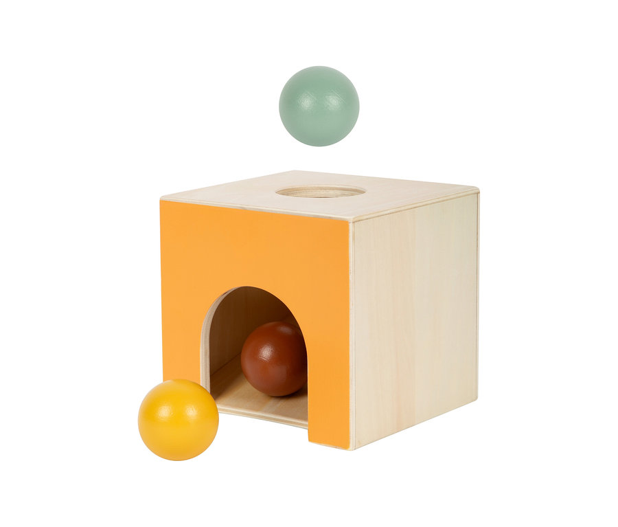 small foot Montessori-Bundle 3: Eine hellbraune Holzkiste mit orangefarbener Vorderseite und einem Bogen. Ein hellgrüner Ball schwebt über einem Loch oben auf der Kiste. Ein brauner Ball liegt im Bogen, ein gelber Ball davor.