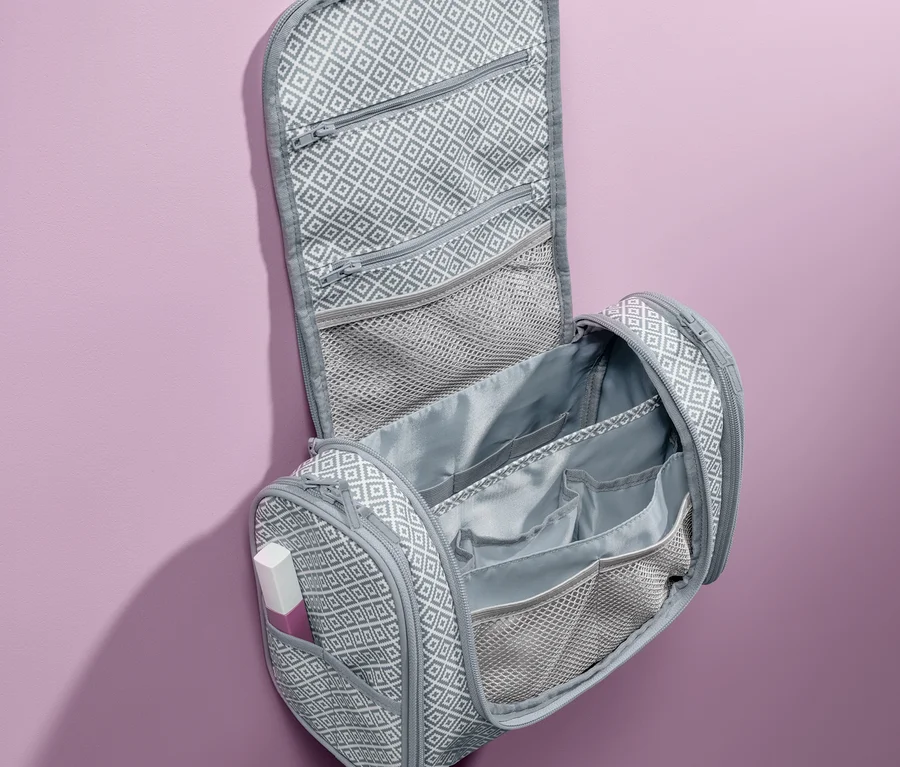 Geöffnete, graue Kulturtasche zum Aufhängen mit geometrischem Muster.