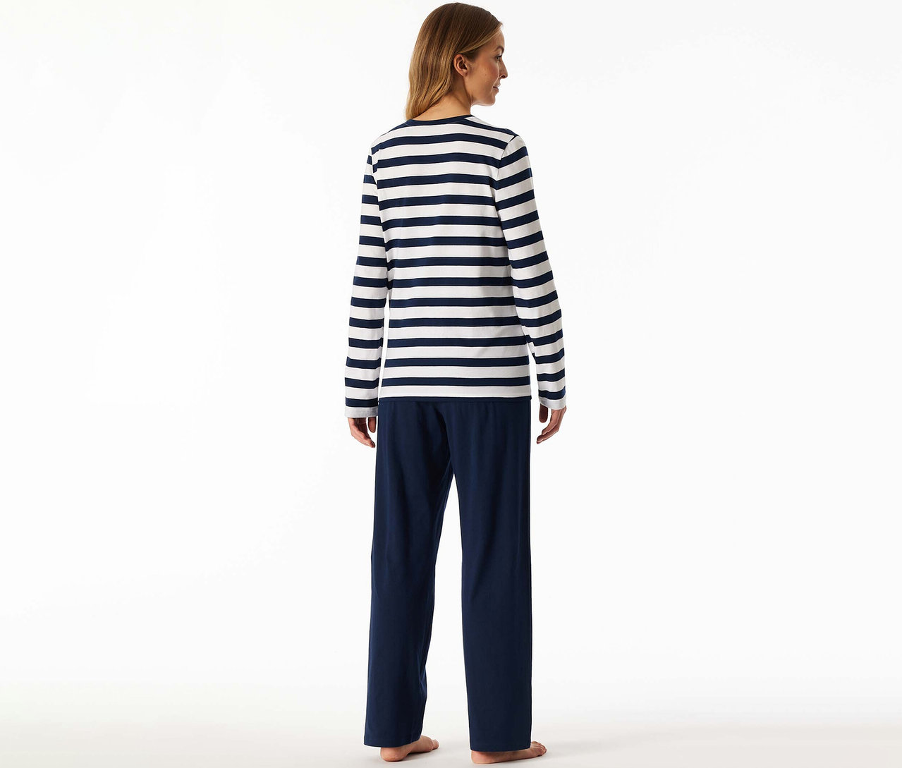 Frau von hinten, trägt ein SCHIESSER Pyjama-Set bestehend aus einem weiß-blau gestreiften Langarmshirt und einer dunkelblauen Hose.