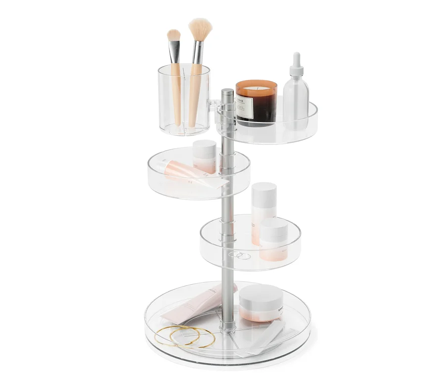 Ein vierstöckiger, drehbarer, transparenter Organizer »Pirouette« mit Kosmetika, Pinseln und einer Kerze.