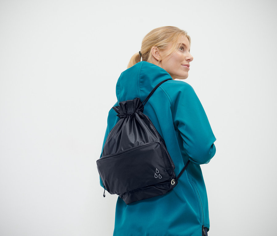 Frau trägt einen marineblauen 2-in-1-Shopper-und-Rucksack.
