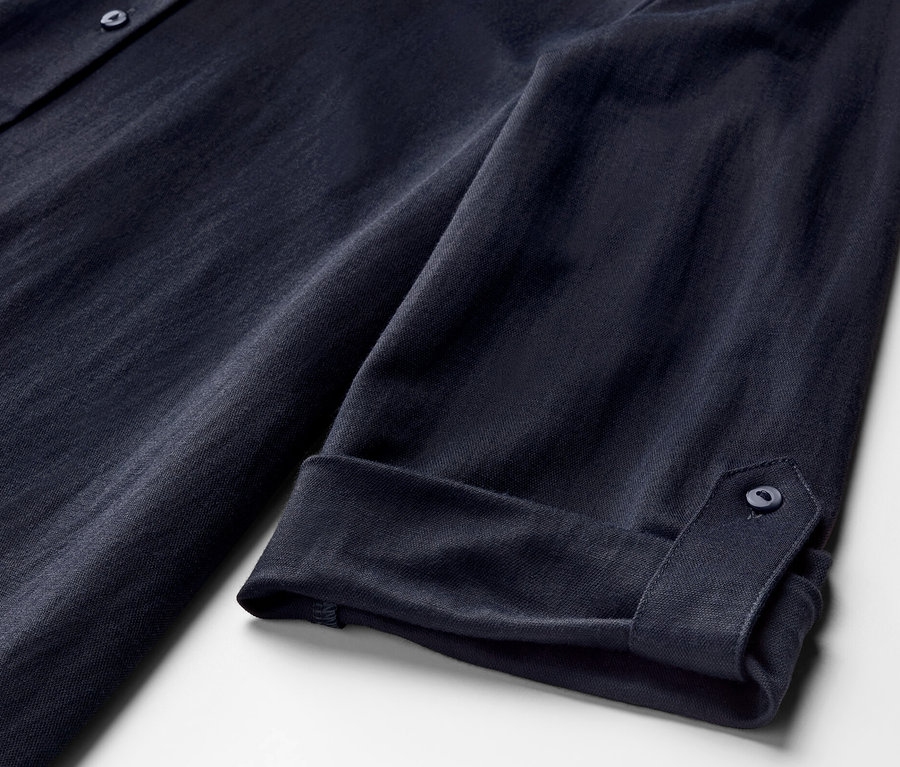 Detailansicht einer dunkelblauen Piqué-Jerseybluse mit hochgekrempelten Ärmeln.