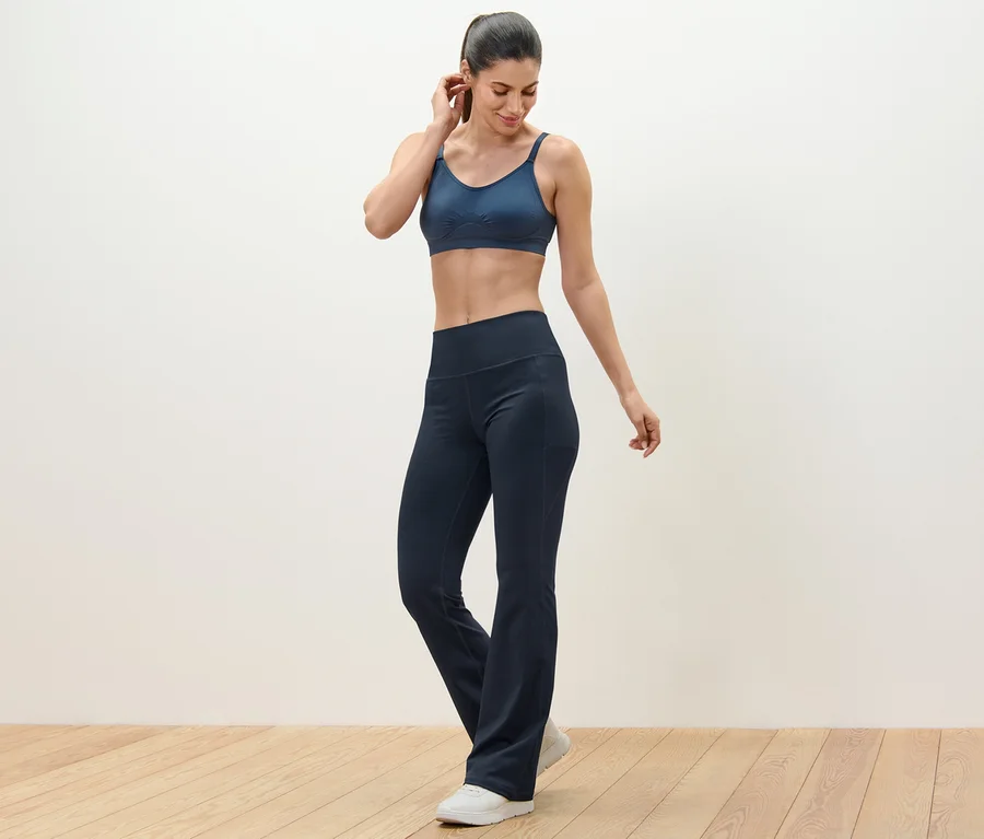 Frau trägt eine Sporthose und einen Sport-BH.