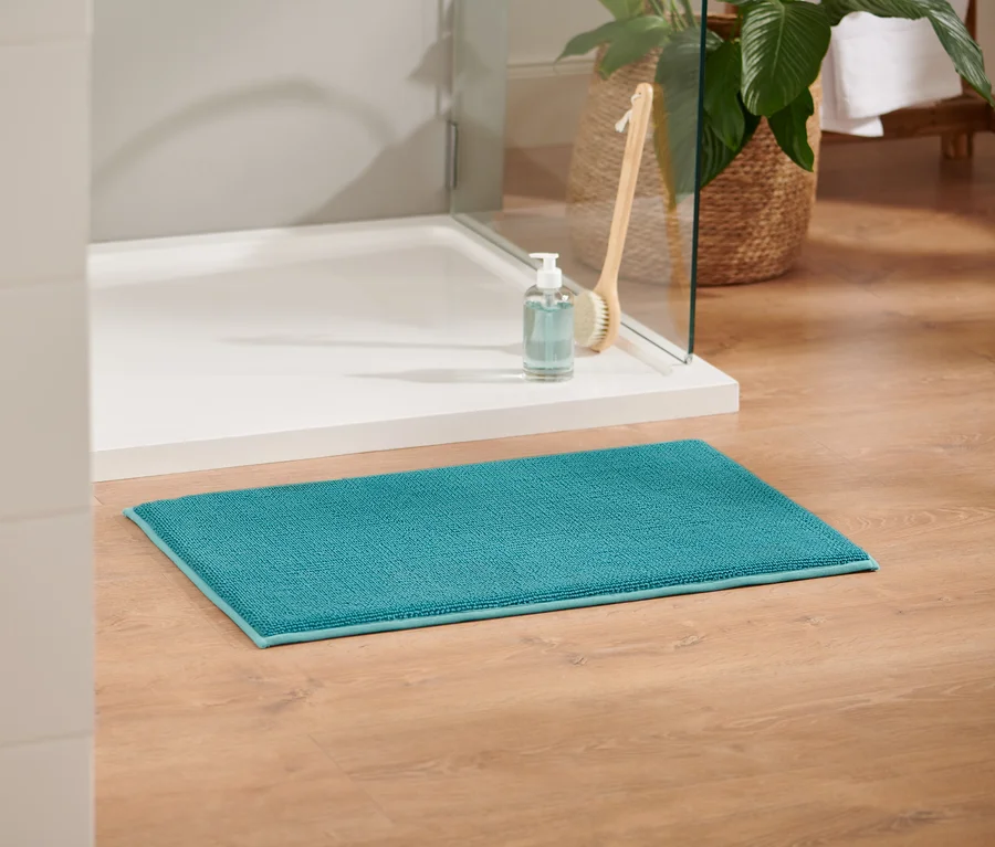 Eine aqua Komfort-Badematte, ca. 45 x 75 cm, liegt auf einem Holzboden.