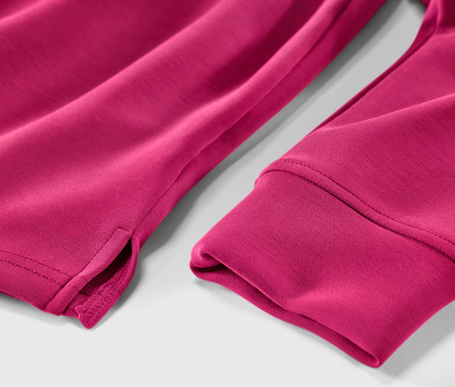 Detailansicht eines pinkfarbenen Hoodies aus Modal-Mix, der den Ärmelsaum und den Schlitz zeigt.