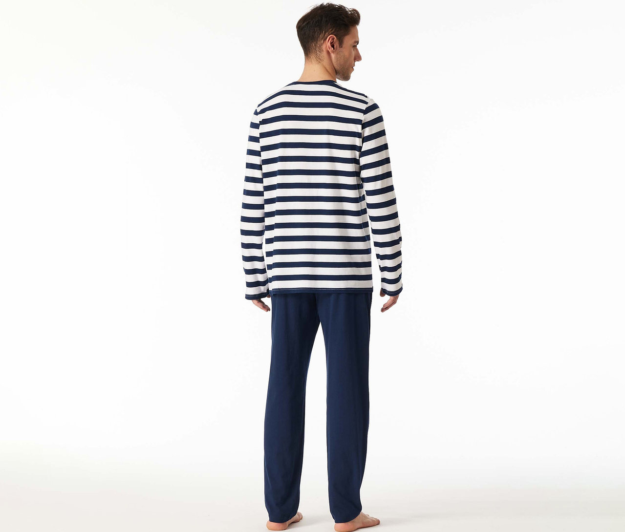 Mann von hinten in einem SCHIESSER Pyjama-Set mit gestreiftem Langarmshirt und dunkelblauer Hose.