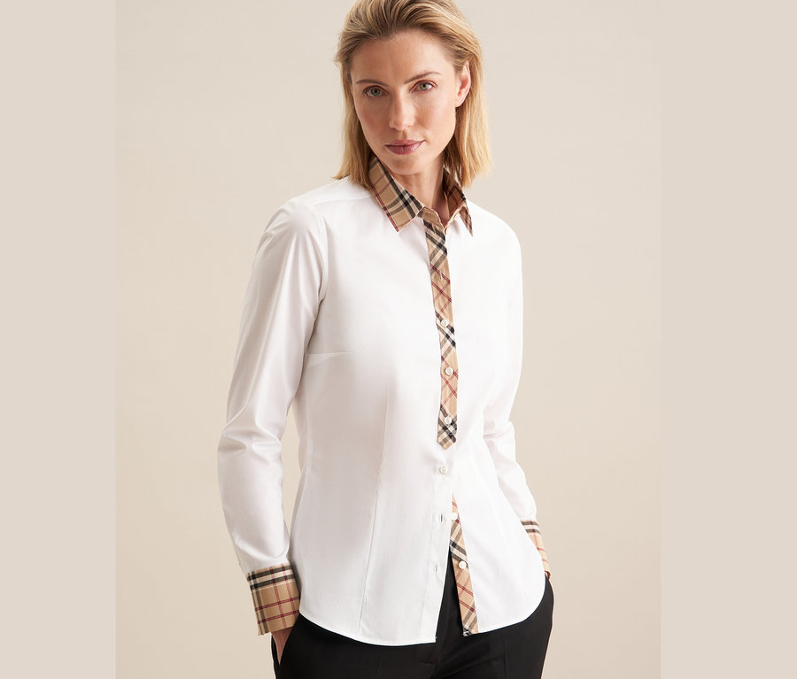 Frau trägt eine weiße Seidensticker Popeline-Bluse mit Karodetail.