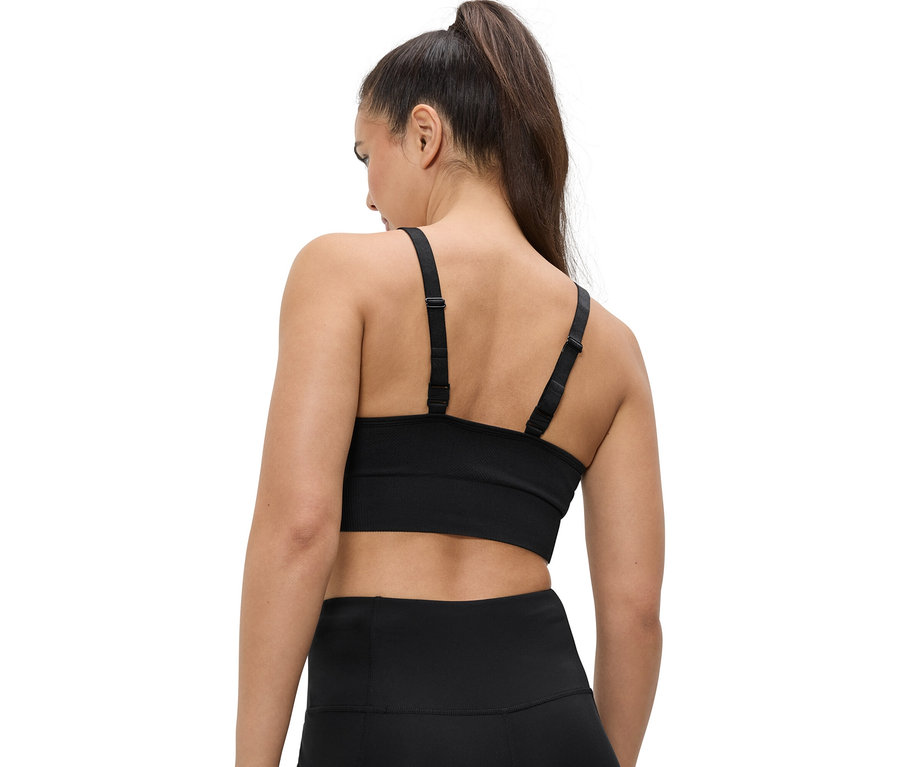 Rückansicht einer Frau mit Pferdeschwanz, die einen schwarzen Sport-BH und Leggings trägt.