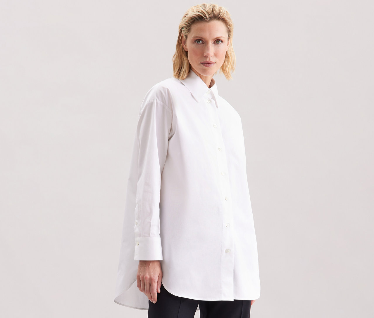 Frau trägt eine weiße Seidensticker Oversize Longbluse.