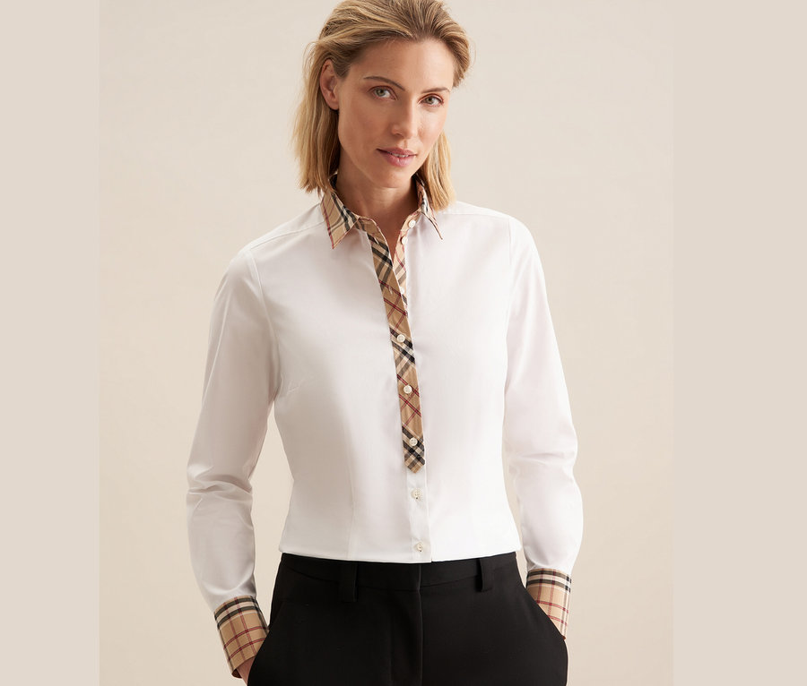 Frau trägt eine weiße Seidensticker Popeline-Bluse mit Karodetail.