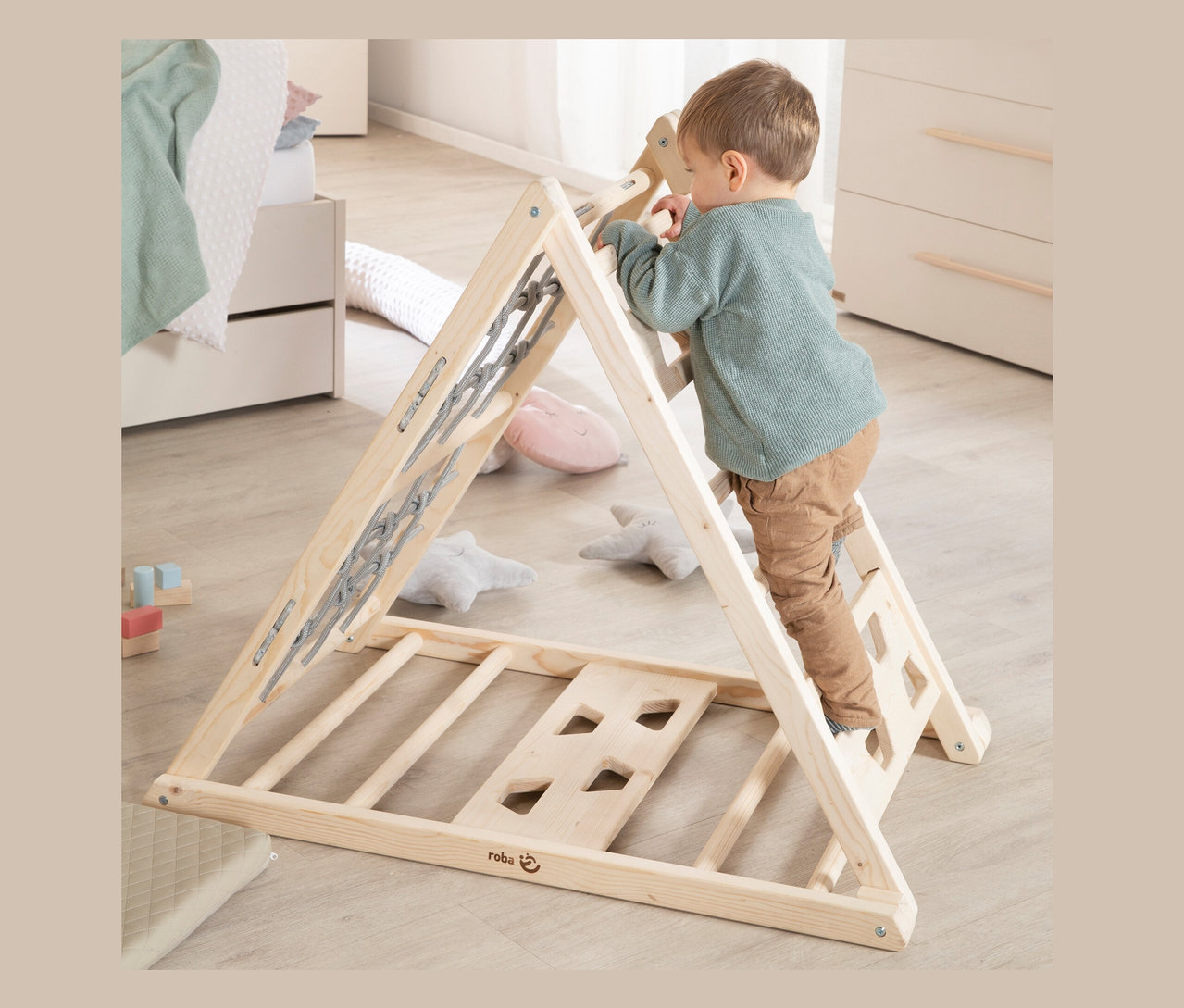 Junge klettert auf roba Kletterdreieck im Kinderzimmer.