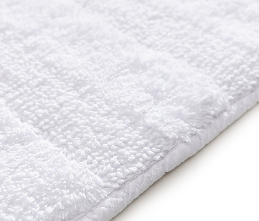 Detailansicht einer weißen Badematte.