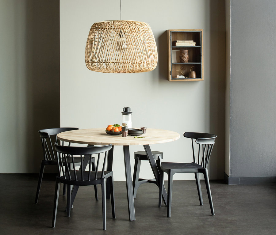 Esstisch mit vier Stühlen, einer Lampe und einem Wandschrank im Hintergrund.