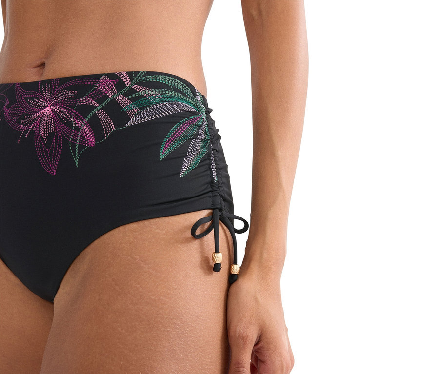 Nahaufnahme einer Frau, die eine schwarze Bikinihose mit Blumenmuster trägt.