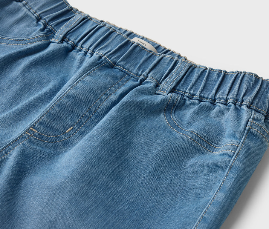 Detailaufnahme einer hellblauen Jeanshose mit elastischem Bund.