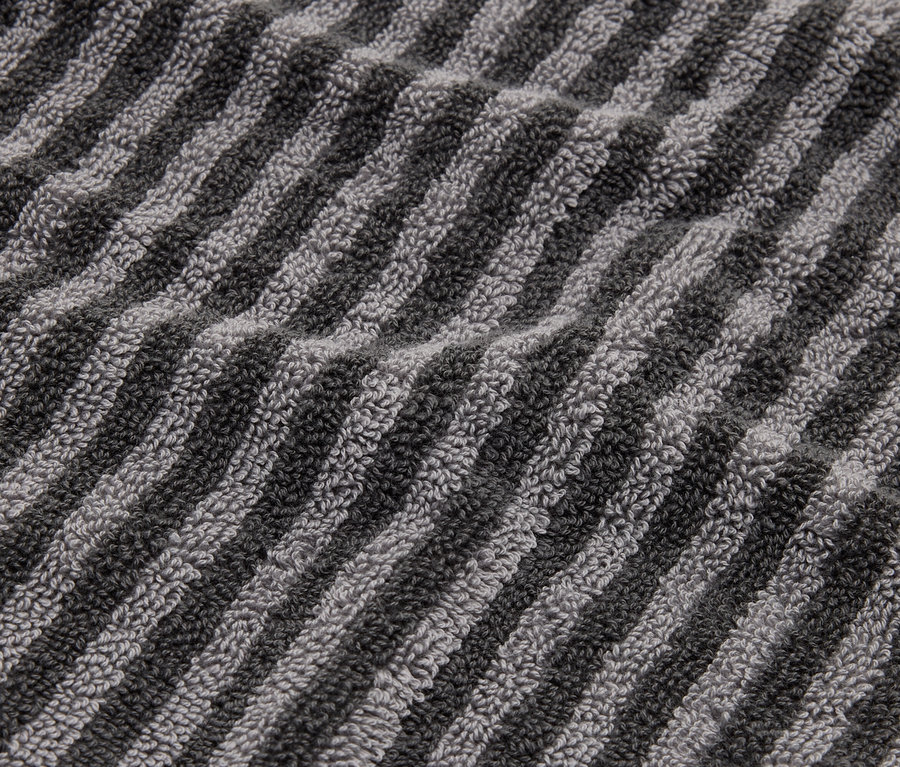 Nahaufnahme eines gestreiften Handtuchs in Grau- und Schwarztönen.