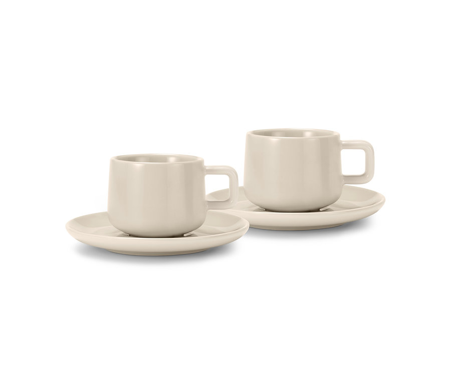 Zwei hellbeige Espressotassen 2er Set mit Untertassen, nebeneinander stehend.