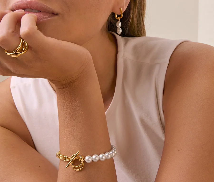 Frau mit Ohrhänger Schlaufe mit Perlen, Ring Loops und Armband halb Perle.