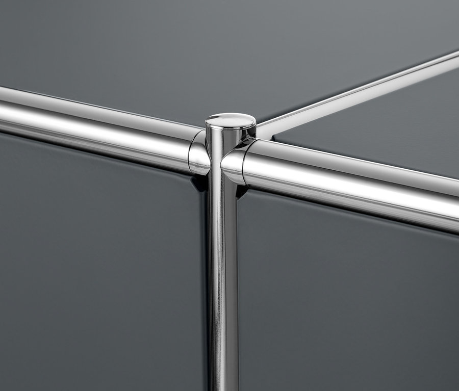 Detailaufnahme eines Metall-Sideboards mit 2 versetzbaren Klappenfächern und einem verchromten Rahmen.