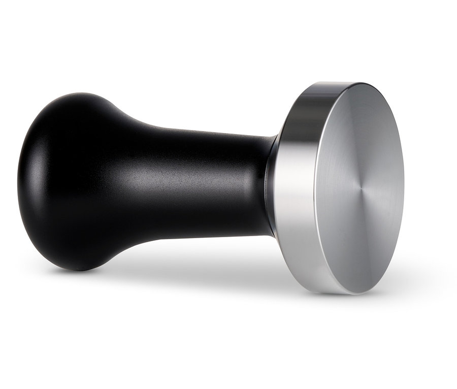 Ein schwarzer Tamper liegt seitlich.