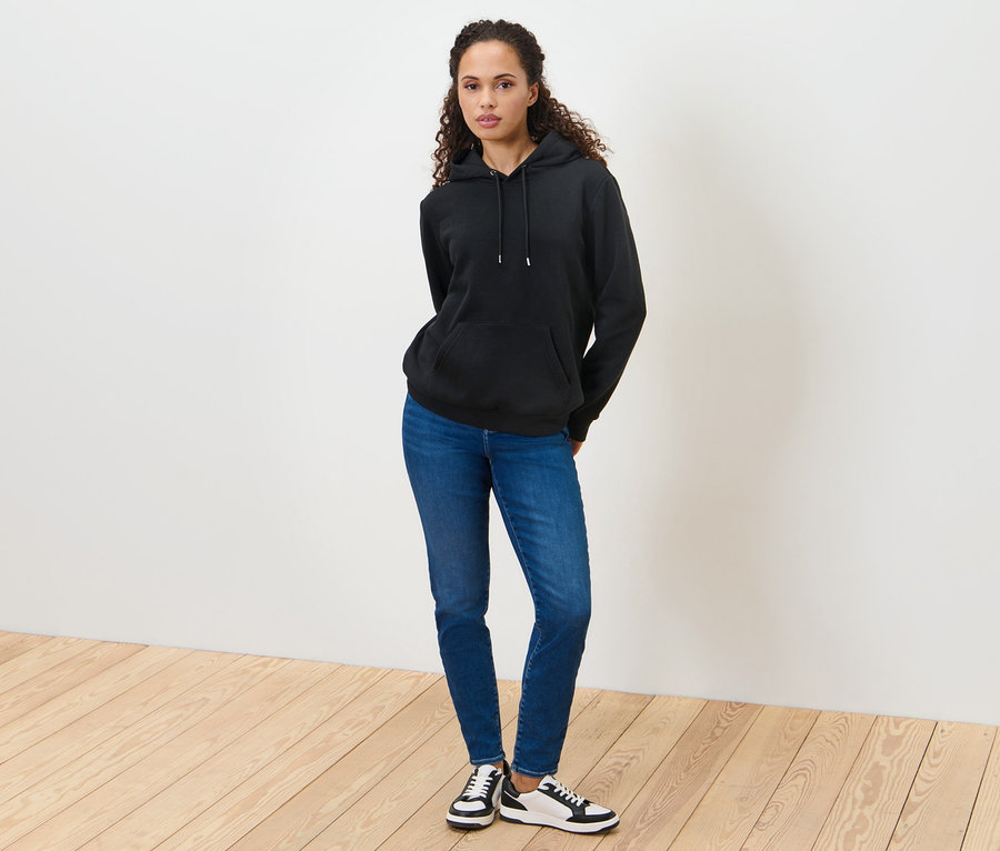Frau steht und trägt einen schwarzen Hoodie.