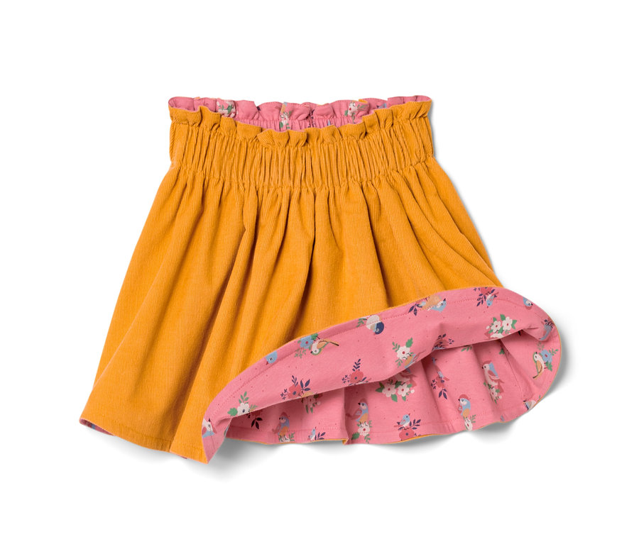 Detailansicht eines Kleinkind-Cord-Wenderocks, goldfarben außen, rosa mit Vogel- und Blumenmuster innen.