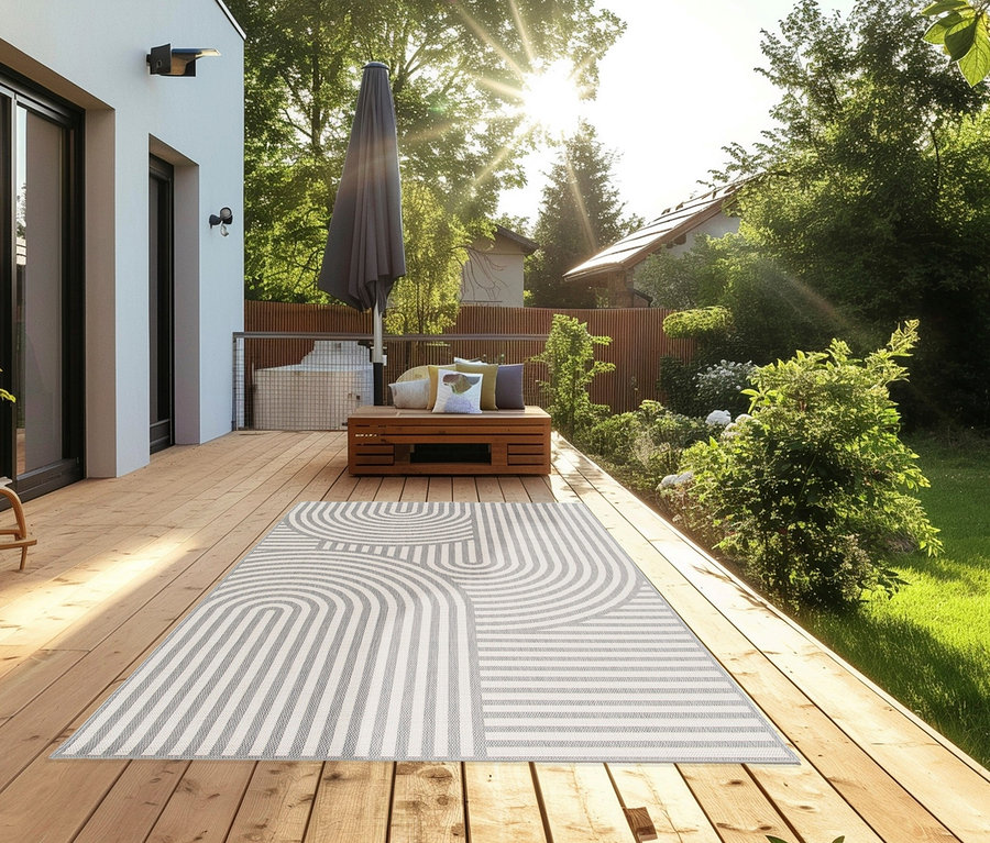 Outdoor-Teppich »Arc Symphony« liegt auf einer Holzterrasse.